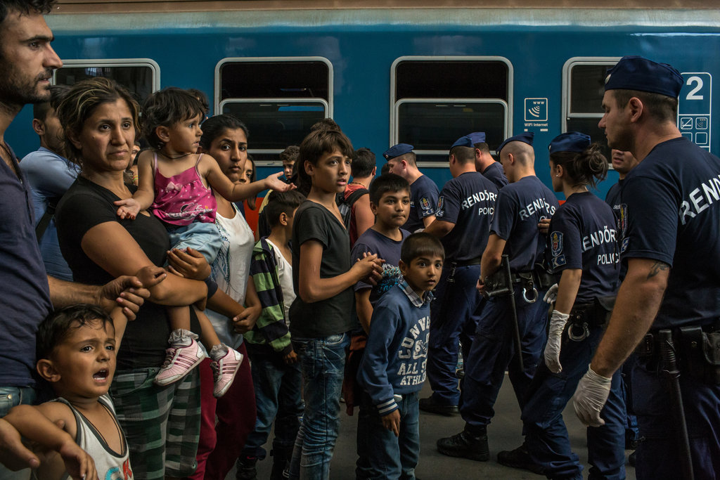 A migrant family faced police officers at the Keleti train station in Budapest. Credit: Mauricio Lima for The New York Times.