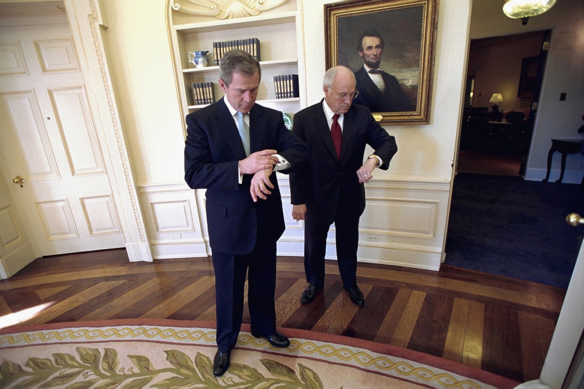 President George W. Bush and Vice President Dick Cheney check their watches in the Oval Office before departing for the swearing-in ceremony for Secretary of State Colin Powell, Jan. 26, 2001. White House Photo by Eric Draper.