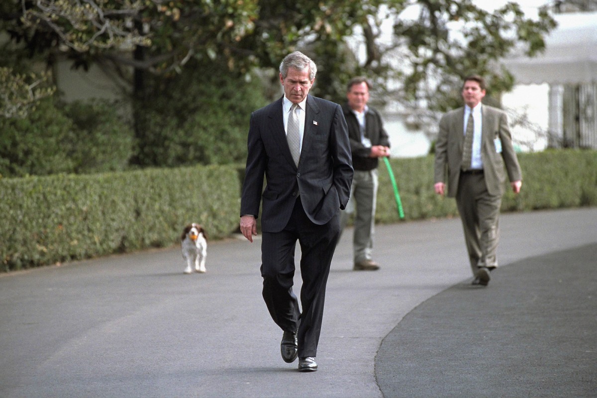 Followed closely by his dog Spot, President George W. Bush walks on the South Lawn Wednesday, March 19, 2003. In an address to the nation that evening, President Bush announced the start of Operation Iraqi Freedom.