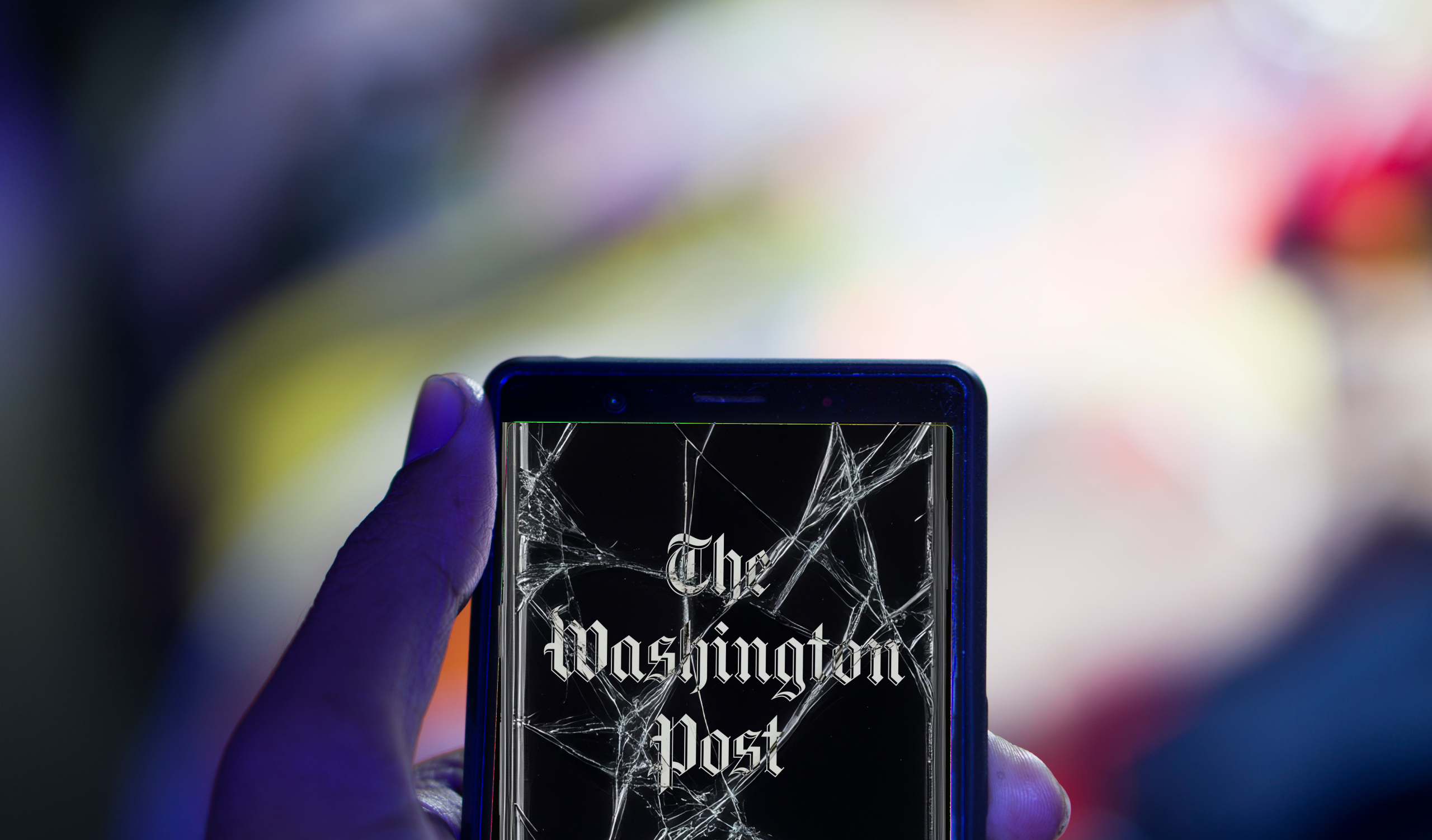Photo shows Washington Post app on a phone with a cracked screen.