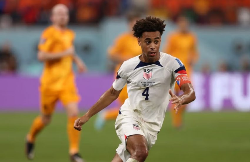 USA soccer player kicking the ball.