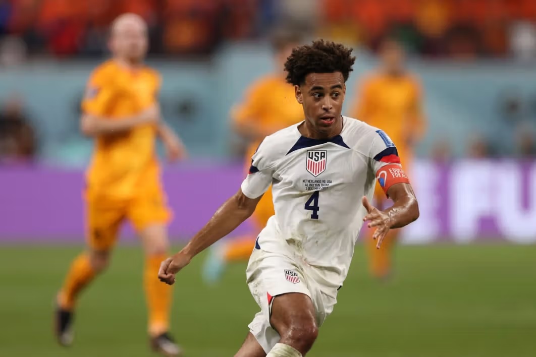 USA soccer player kicking the ball.